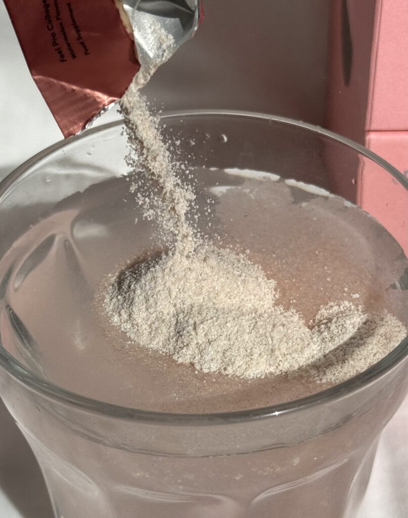 Pouring collagen powder into a glass full of water