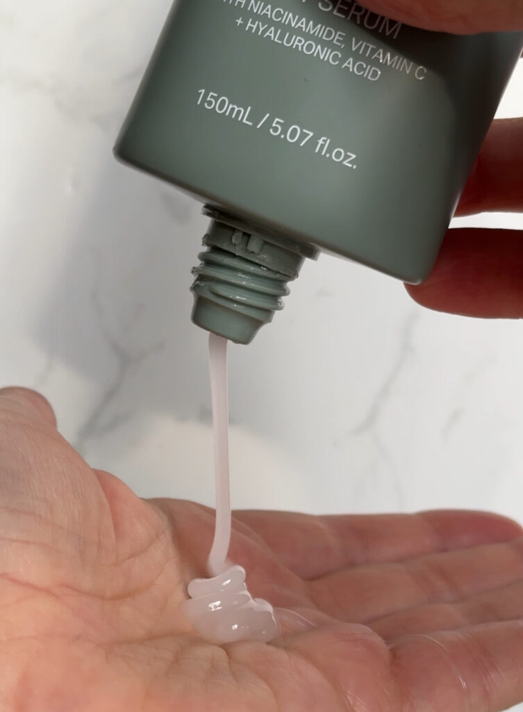 Squeeze nozzle dispenser of the body serum in use