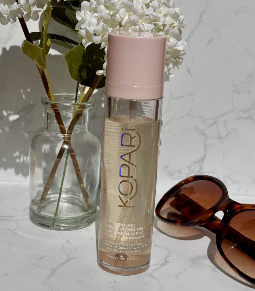 Kopari Sunglaze Sheer Setting Mist bottle with sunglasses