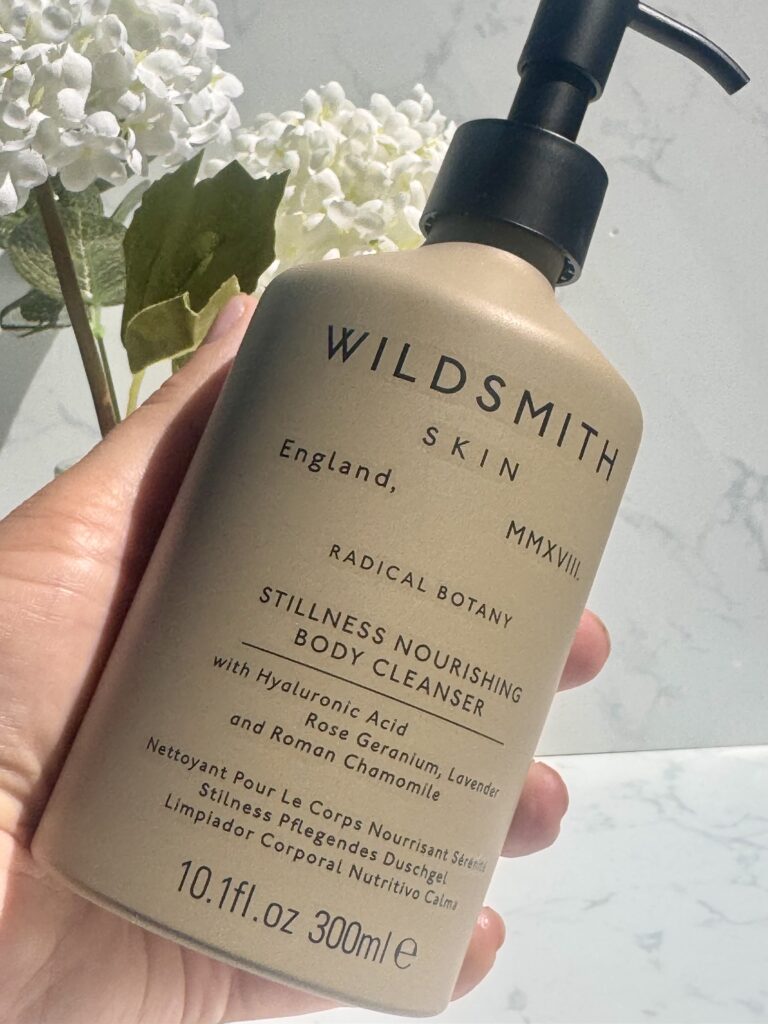 Holding the Wildsmith Skin Stillness Nourishing Body Cleanser in hand