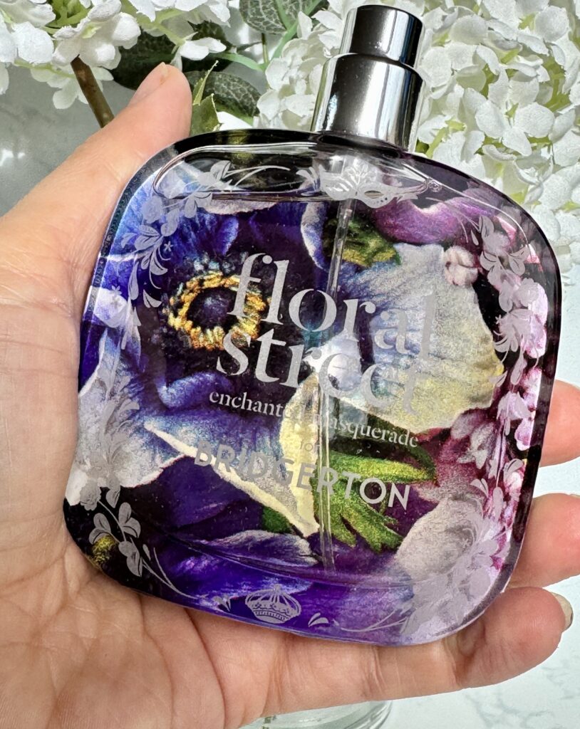 Holding the bottle of Floral Street Enchanted Masquerade in hand