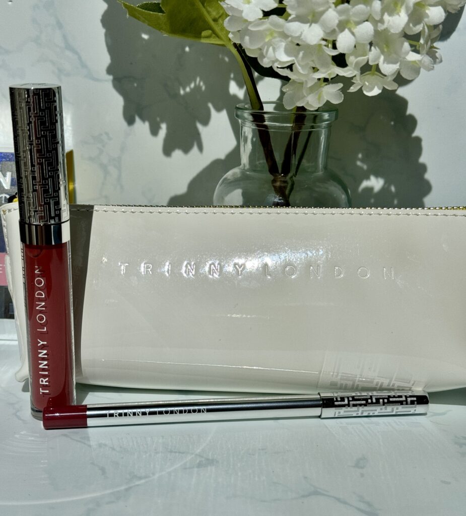 Trinny London Lip Reset Kit including Sheer Joy Pro Collagen Lip Oil and Lip2Define Lip Liner alongside beauty bag